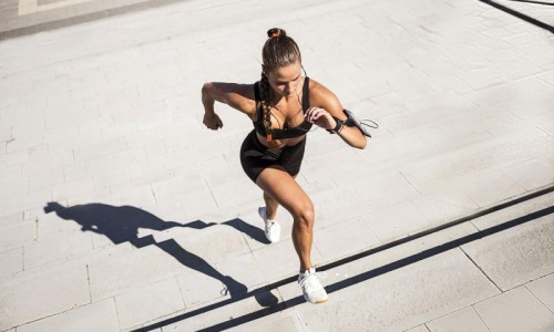 Get your workout on woman exercises running outside up stairs
